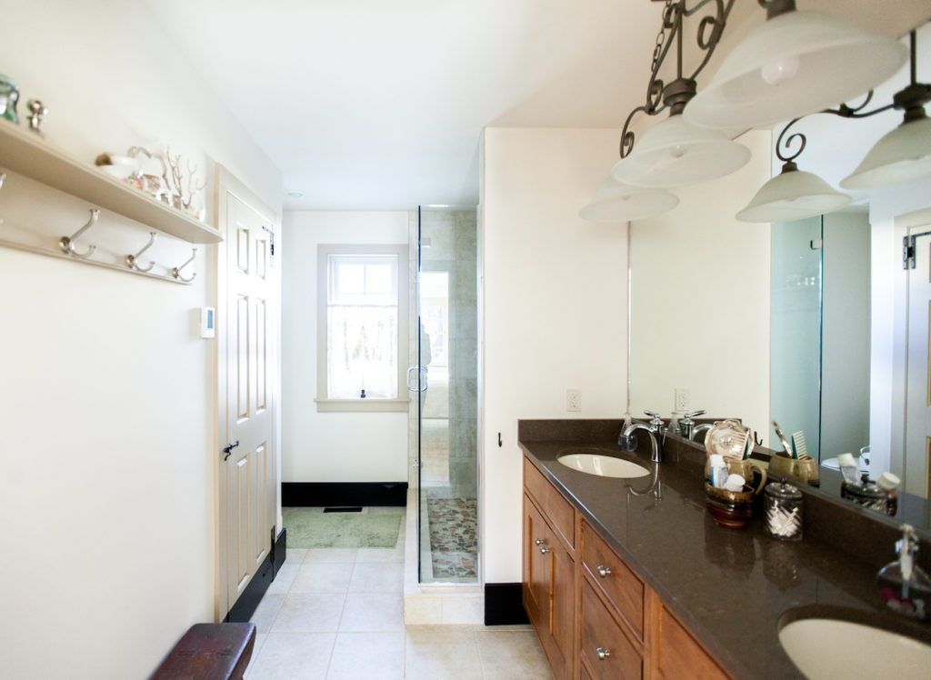 Full bathroom with two sinks and glass door shower in olde bulltown home