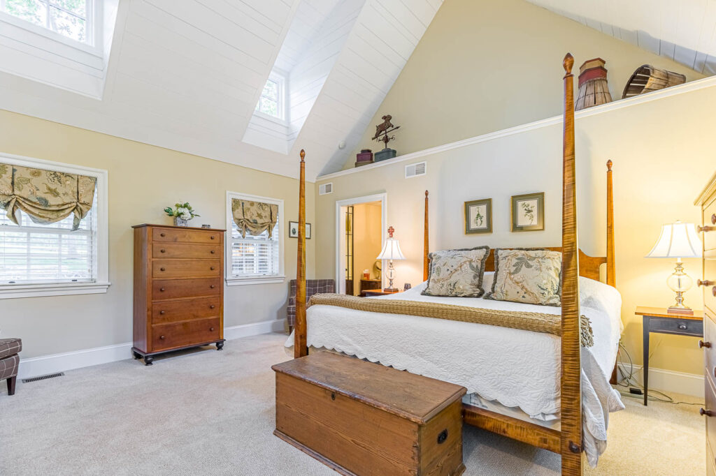 Large bedroom with bathroom attached and a high ceiling in an olde bulltown home