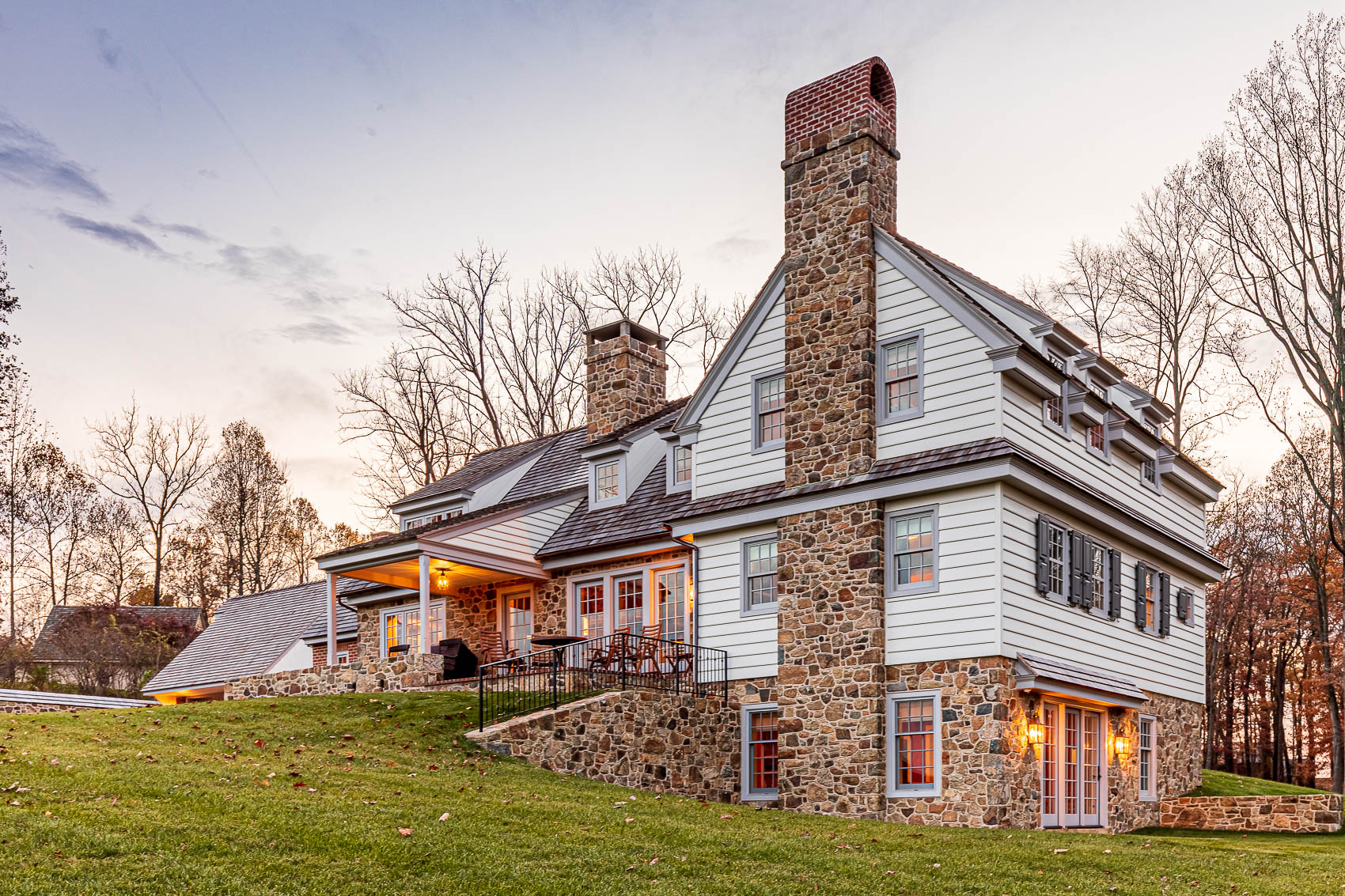 Front elevation of a home with white siding and stone accents in olde bulltown