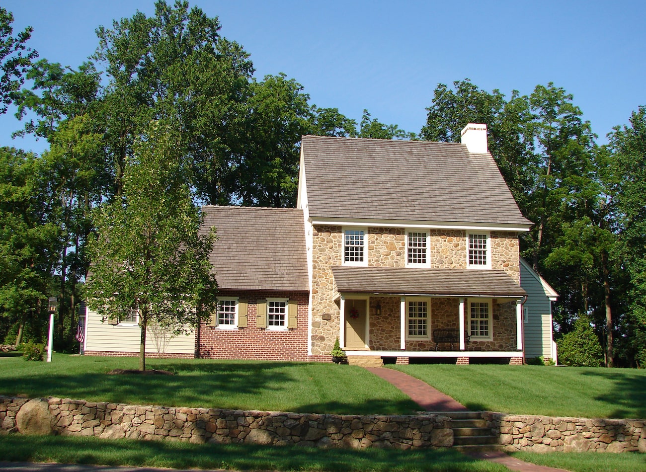 Front elevation of a stone home with brick accents in olde bulltown